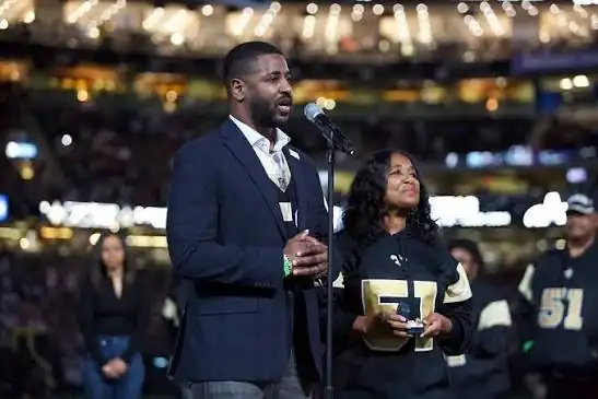 Marcus Mills speaking on behalf of the Mills family at a stadium ceremony honoring Sam Mills